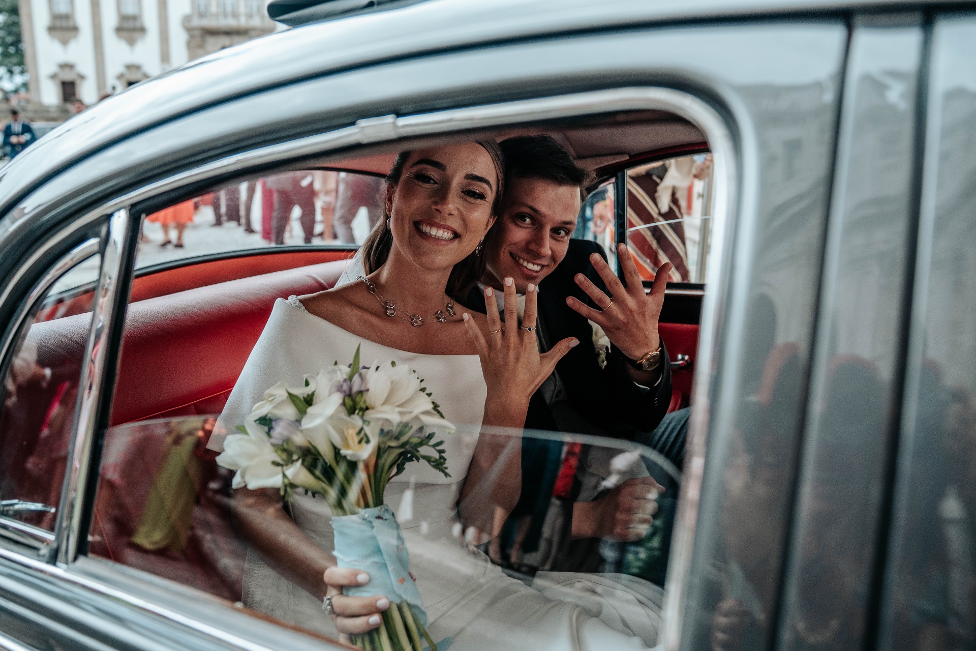 Noivos no carro clássico com alianças